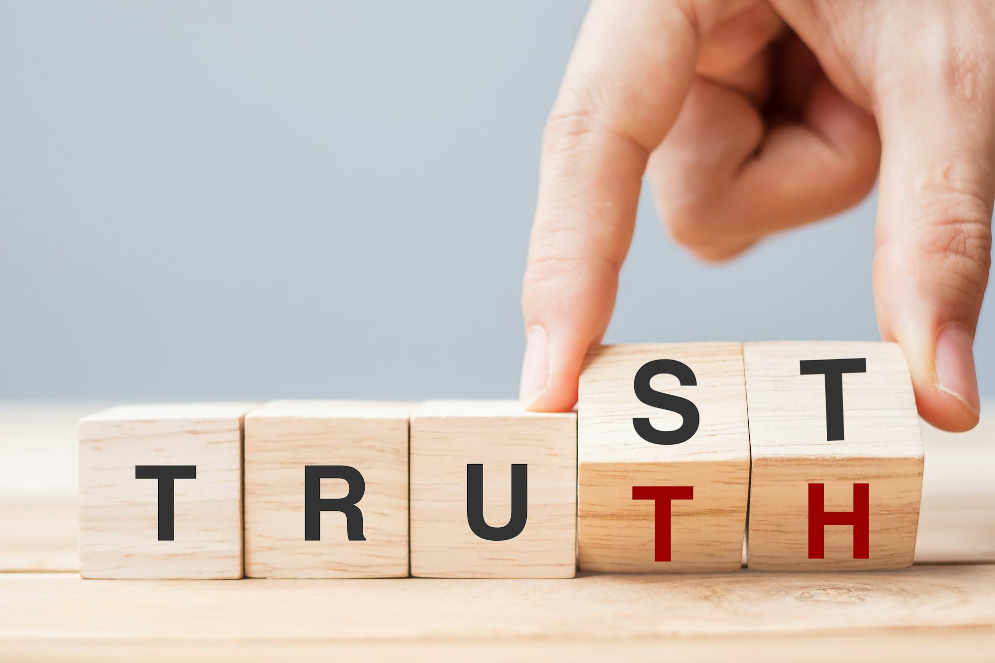 Business man hand change wooden cube block with TRUST and TRUTH business word on table background.