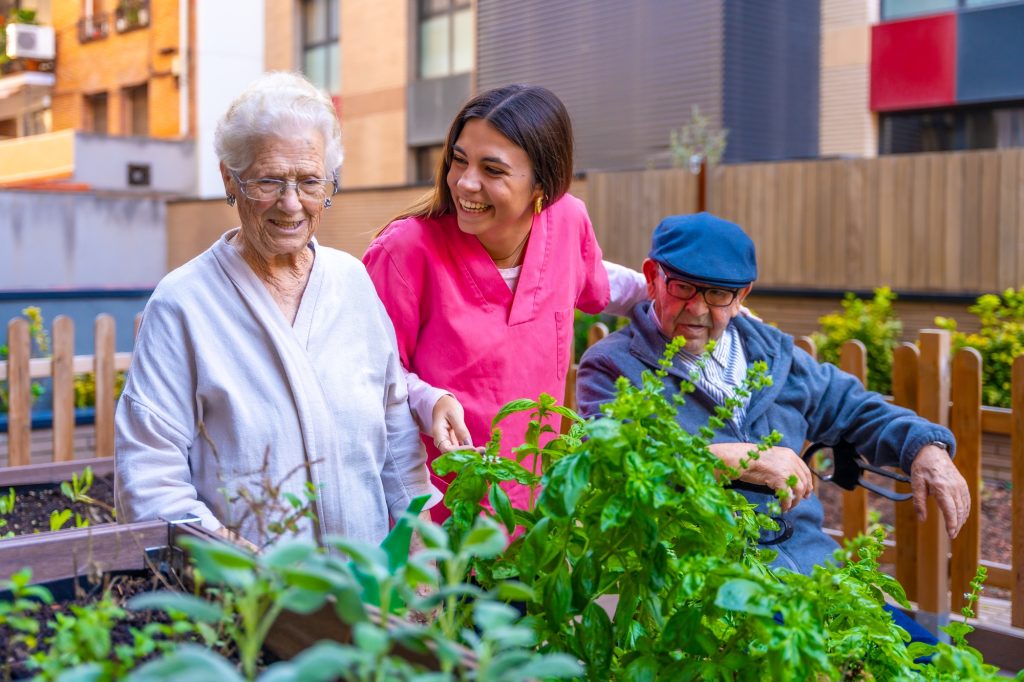 Nurse and elder people in a garden in a geriatric